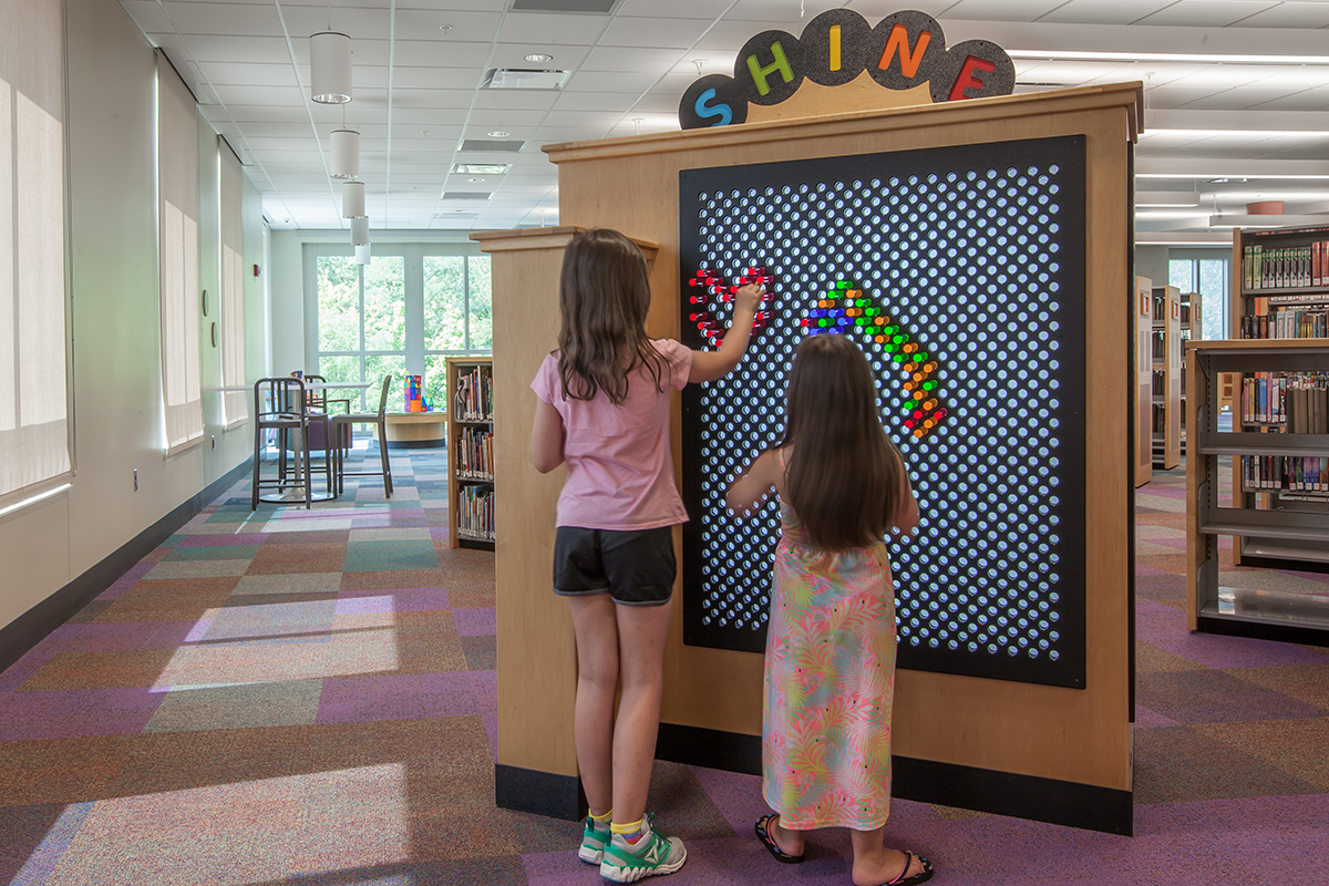 two girls playing with a light bright